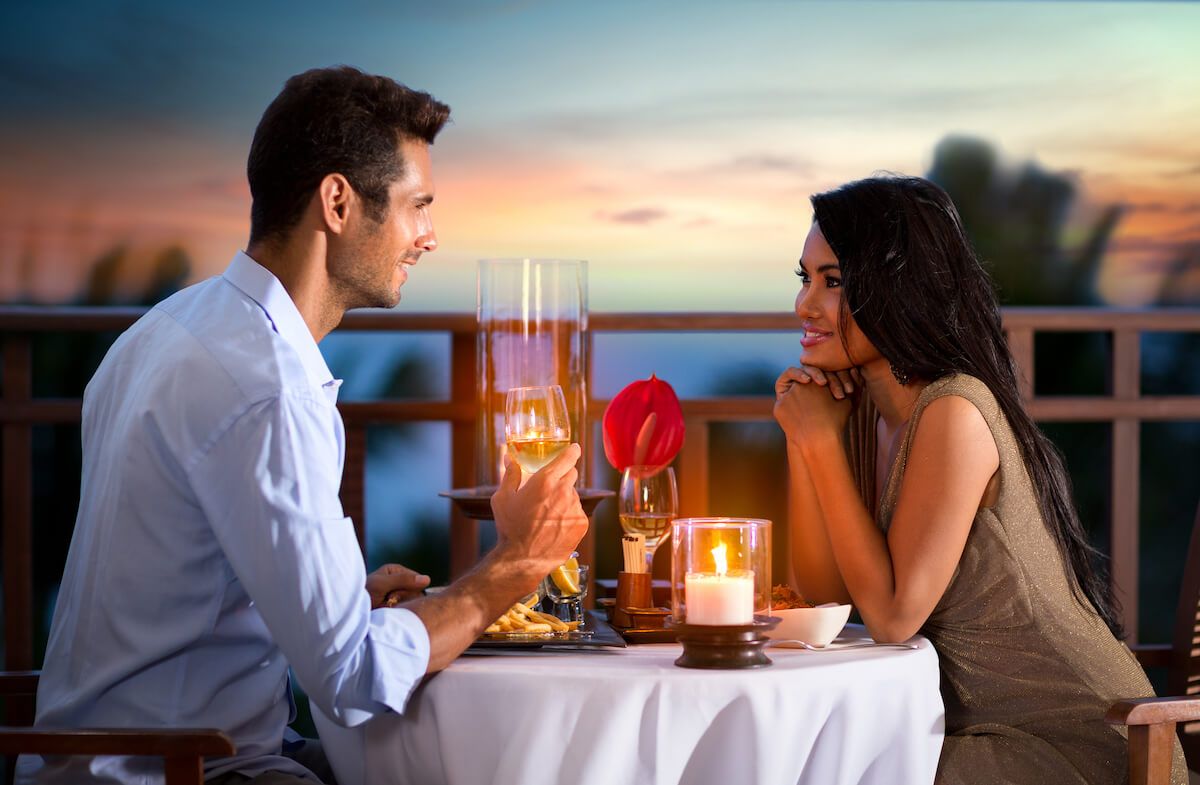 Find out the best restaurants on Maui with a view recommended by top Hawaii blog Hawaii Travel Spot! Image of a man and woman on a romantic dinner date at sunset