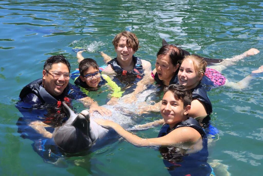 Image of a family petting a dolphin on Oahu