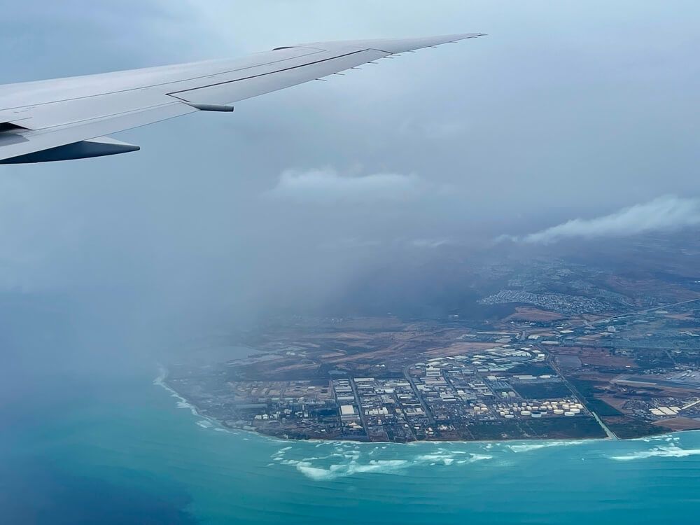 Image of an airplane wing over an aerial shot of Kauai