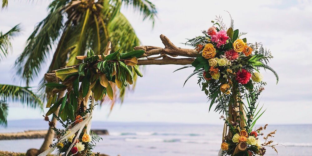 Image of a stick arch covered with tropical flowers for a wedding in Hawaii