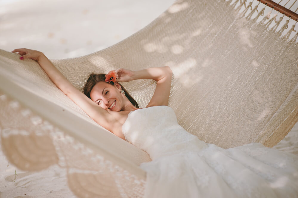 Image of a bride lounging in a hammock while wearing a wedding dress