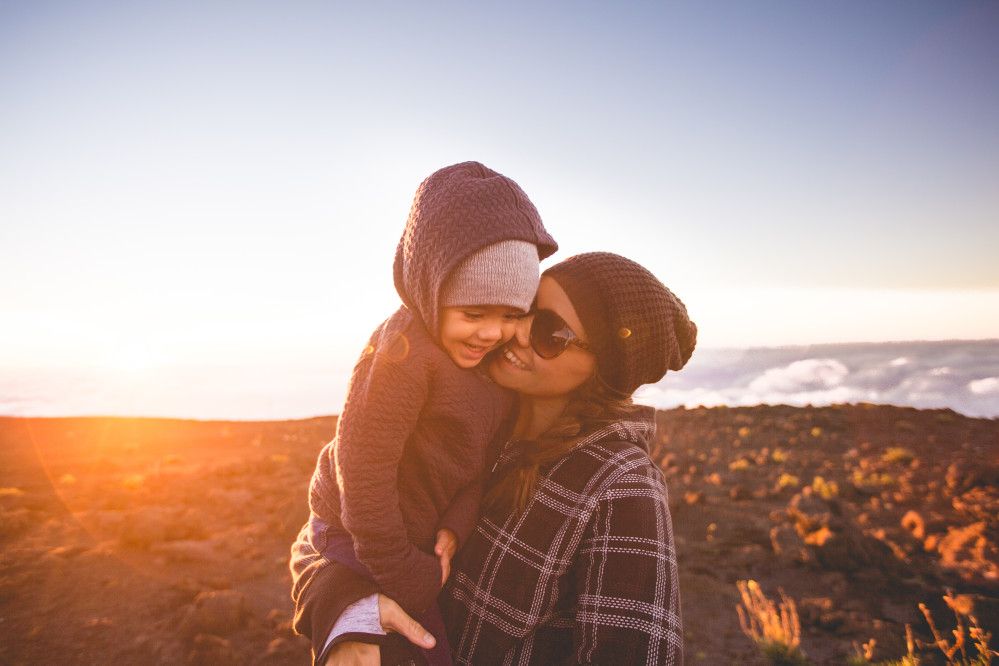 Image of a mom and daughter snuggling at Haleakala National Park on Maui