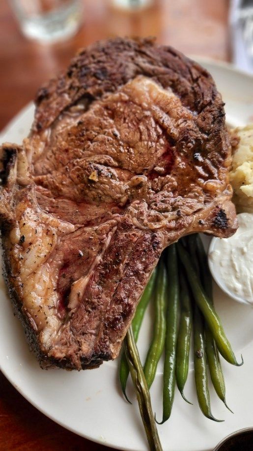 Image of a white plate with prime rib and green beans on it from Haleiwa Joe's