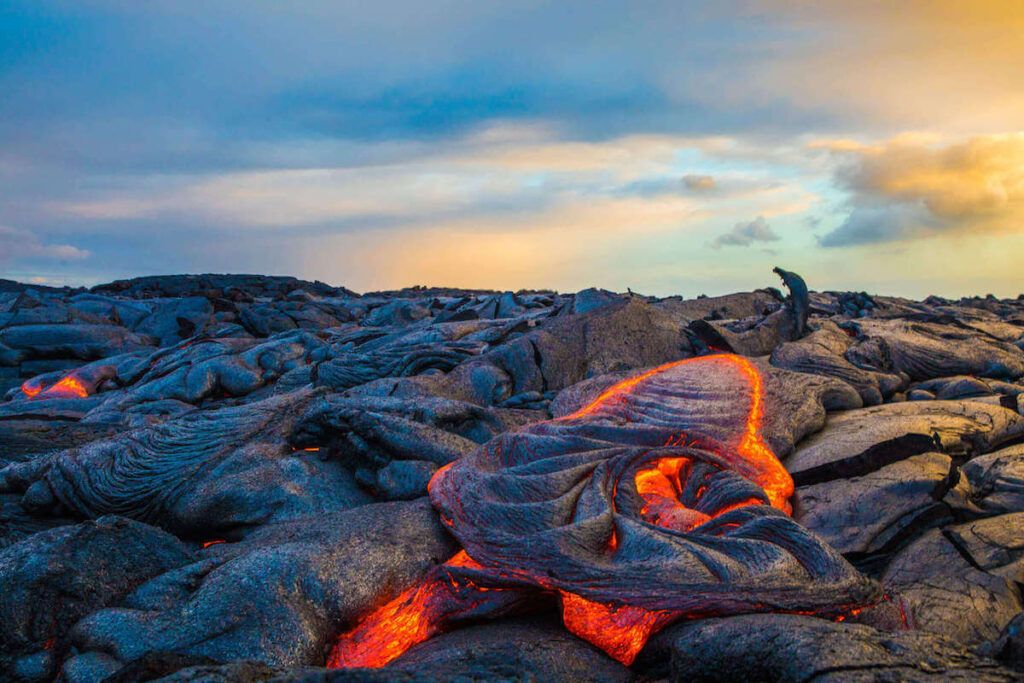 Image of lava bubbling under black cooled lava at Hawaii Volcanoes National Park on the Big Island of Hawaii