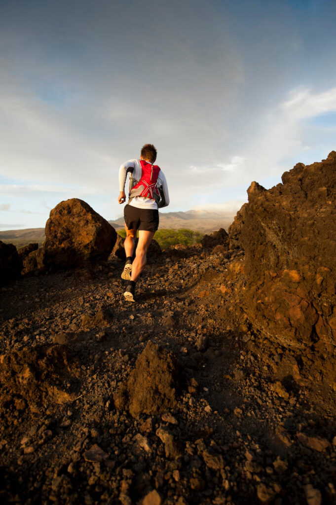 Image of a man running along the Hoapili Trail covered in lava rocks