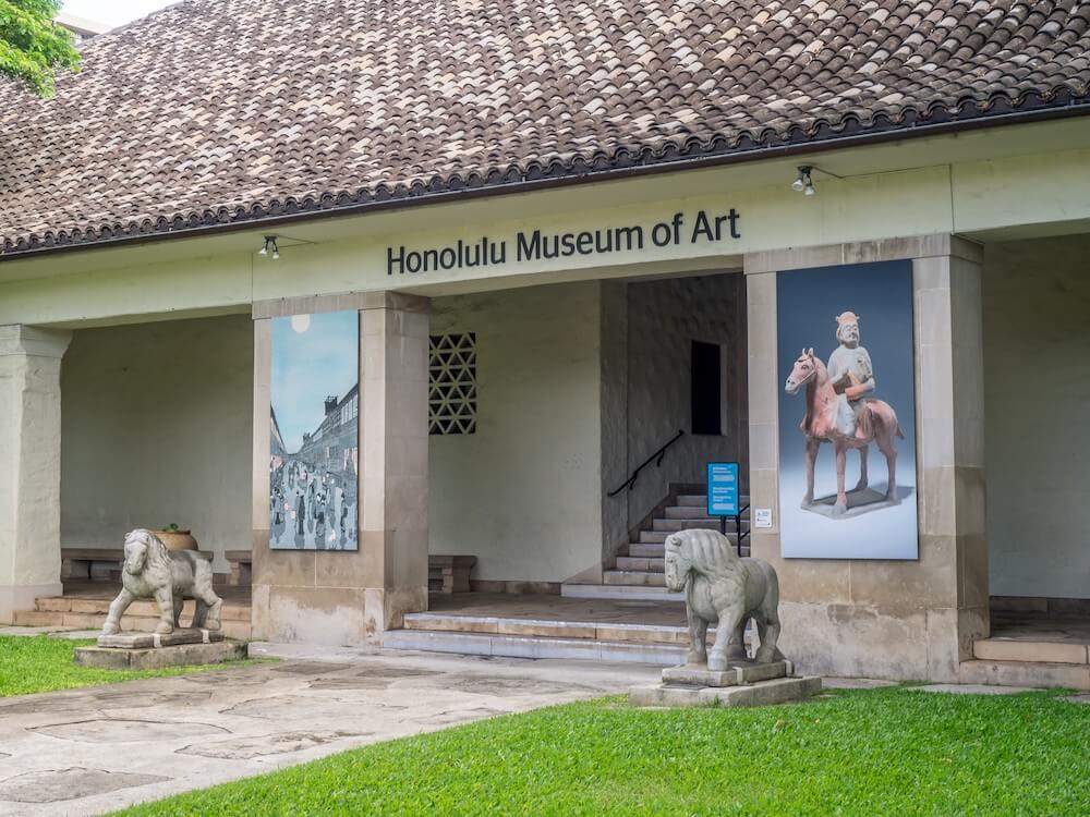 Image of the entrance to the Honolulu Museum of Art with stone lions on either side