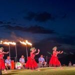 Find out the best luau in Maui for your next trip recommended by top Hawaii blog Hawaii Travel Spot! Image of hula kahiko dancers wearing red costumes at the Feast at Mokapu. Photo credit: Marcie Cheung publisher of HawaiiTravelSpot.com