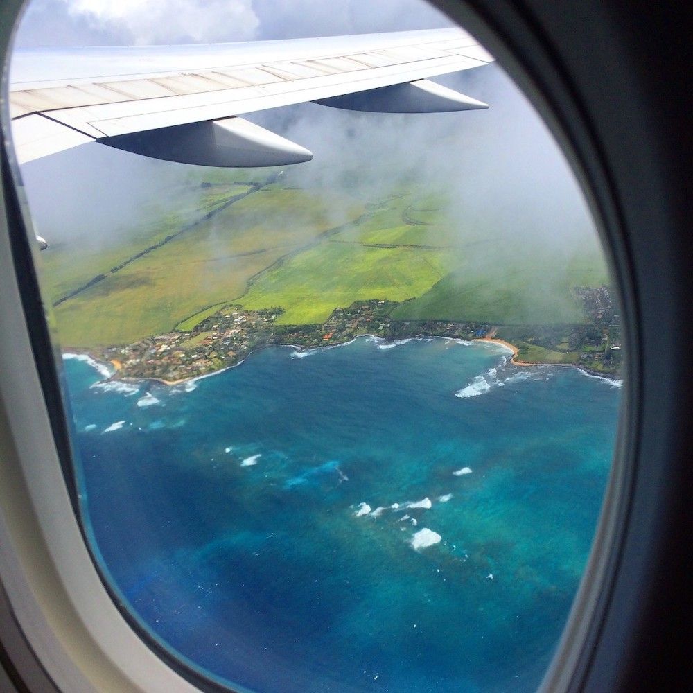 Image of an airplane window overlooking Maui