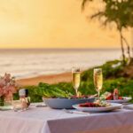 Find out the best Kauai romantic restaurants recommended by top Hawaii blog Hawaii Travel Spot! Image of a beachside table with wine and food on it