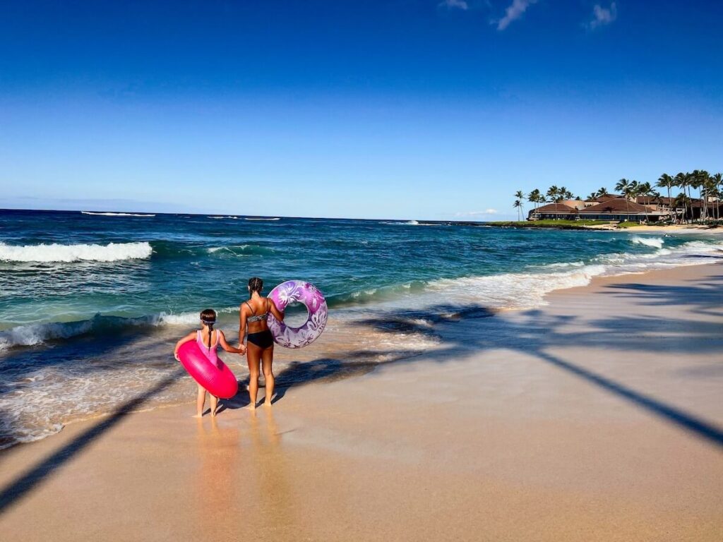 Image of two girls holding inflatables at Poipu Beach on Kauai