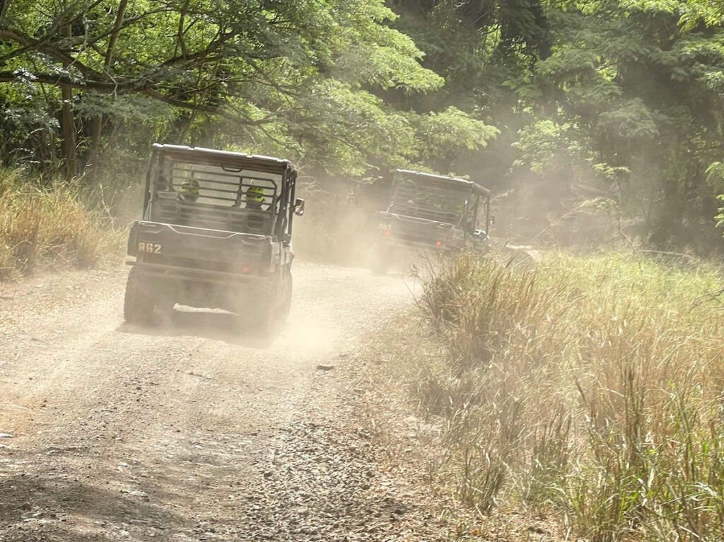 Image of two UTVs driving on a dusty road at Kualoa Ranch in Hawaii