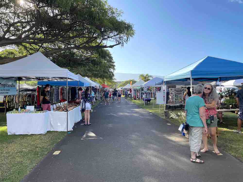 Image of a bunch of booths lining a paved path at the Maui Swap Meet