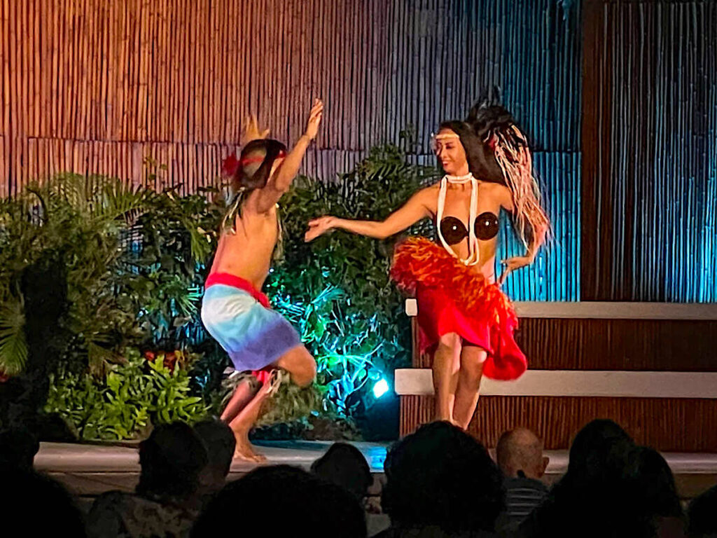 Image of a woman and man doing Tahitian dancing on stage at a Maui luau.