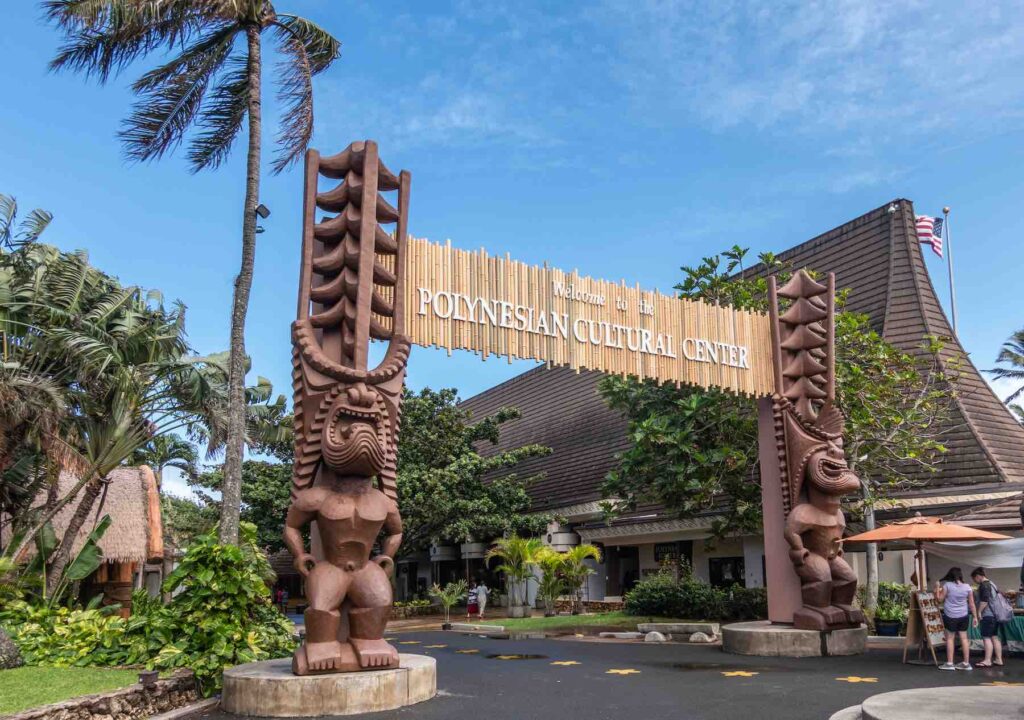 Image of the Polynesian Cultural Center sign with two large tiki statues