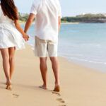 Find out the most romantic honeymoon activities in Maui recommended by top Hawaii blog Hawaii Travel Spot! Image of a man and woman walking on the beach away from the camera