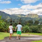 Find out the most romantic Kauai honeymoon resorts recommended by top Hawaii blog Hawaii Travel Spot! Image of a couple holding hands walkind down a path in North Shore Kauai