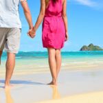 Check out this list of romantic quotes about traveling with your love compiled by top Hawaii blog Hawaii Travel Spot! Image of a couple holding hands on a Hawaii beach