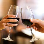 Find out the most romantic restaurants in Kona Hawaii recommended by top Hawaii blog Hawaii Travel Spot! Image of two people clinking red wine glasses