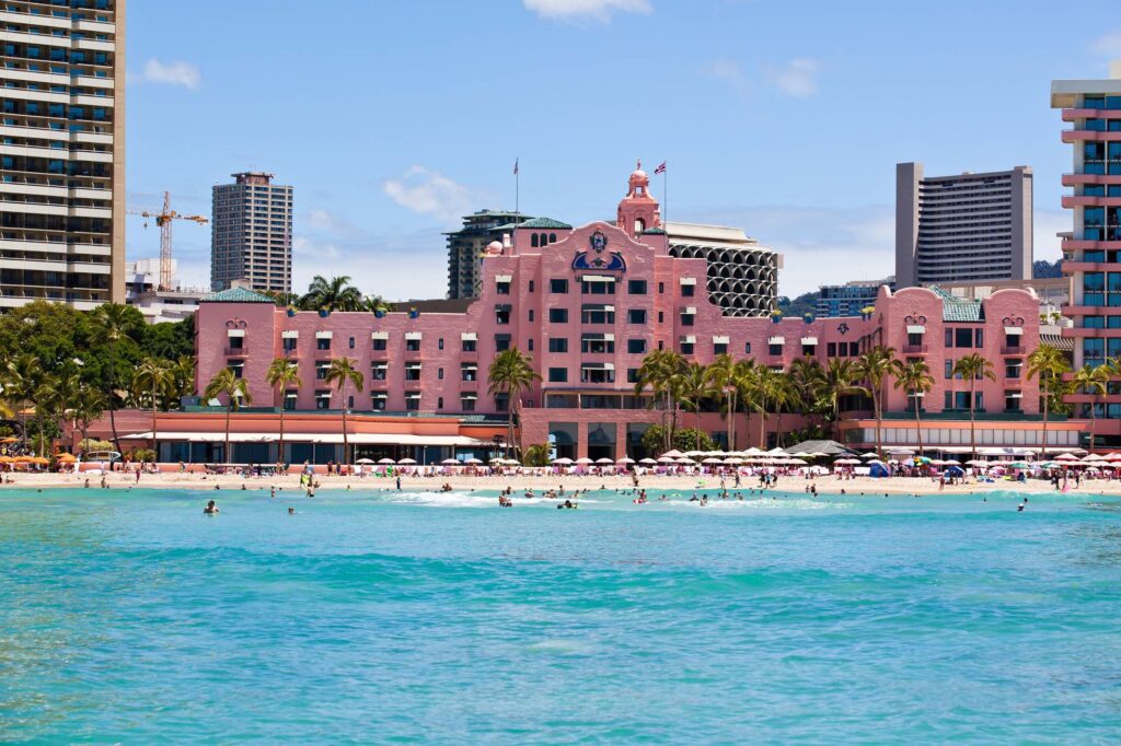 Image of a bright pink hotel on the beach at Waikiki Oahu