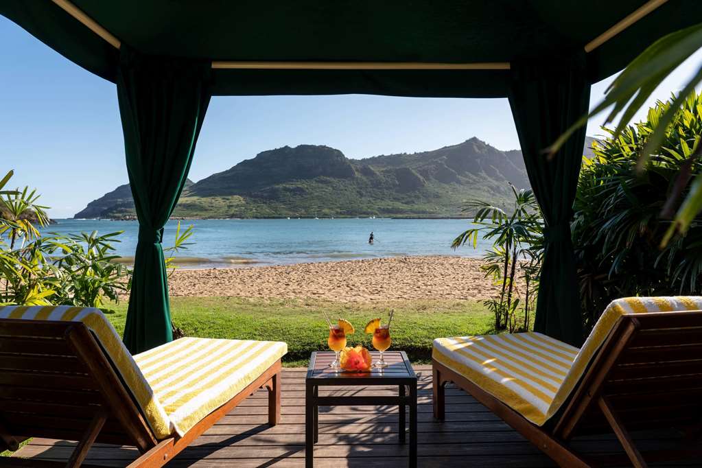 Image of two beach lounge chairs in a cabana overlooking Kalapaki Bay on Kauai