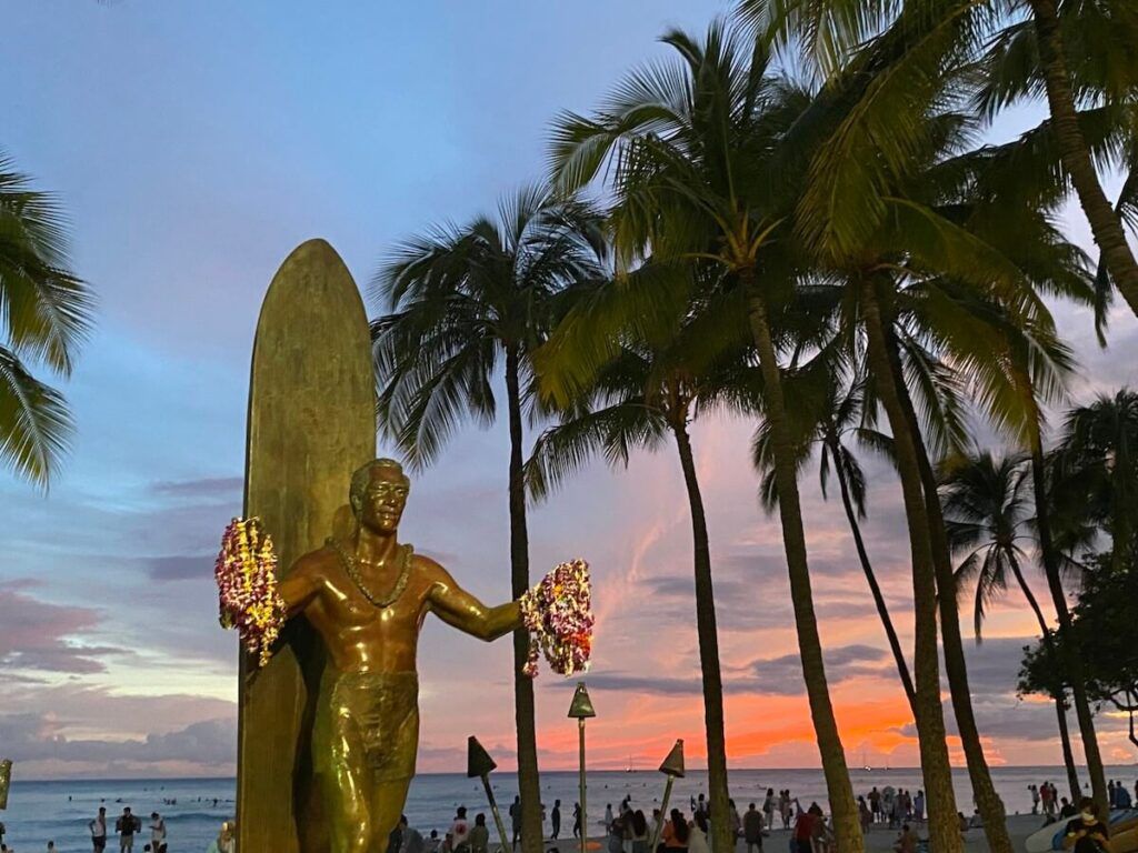 Image of the sunset behind the Duke Kahanamoku statue in Waikiki