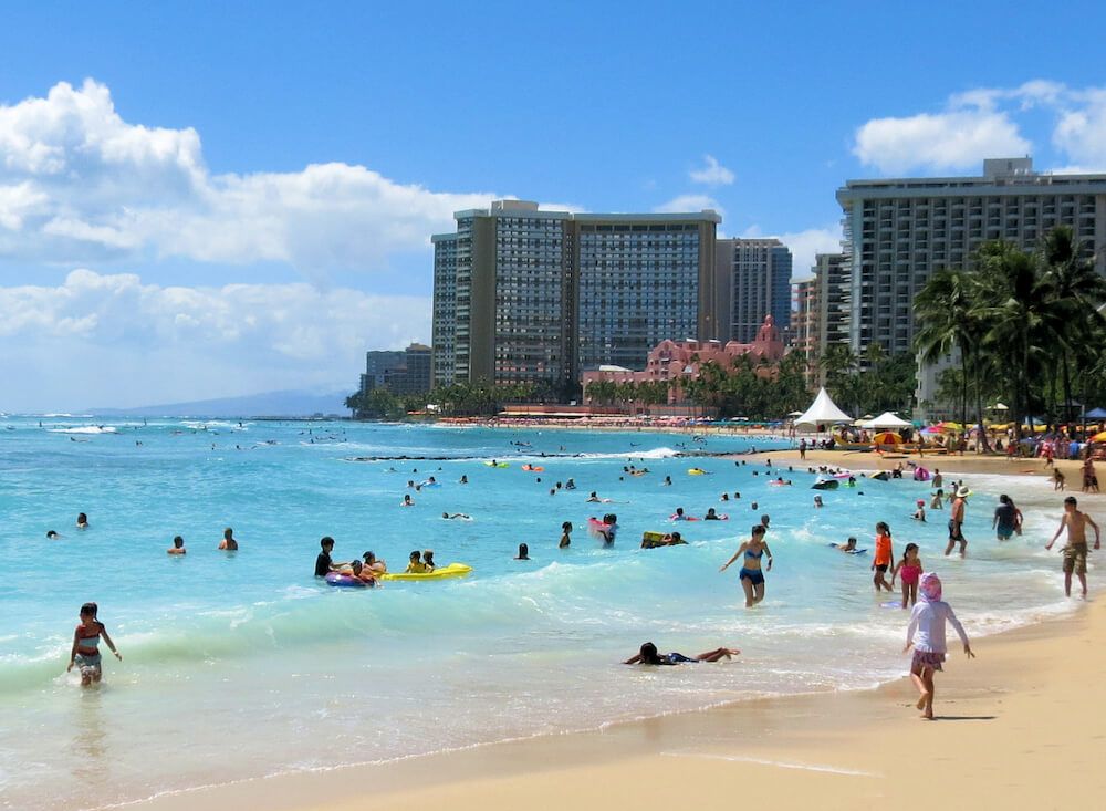 Image of Waikiki Beach with people playing in the water