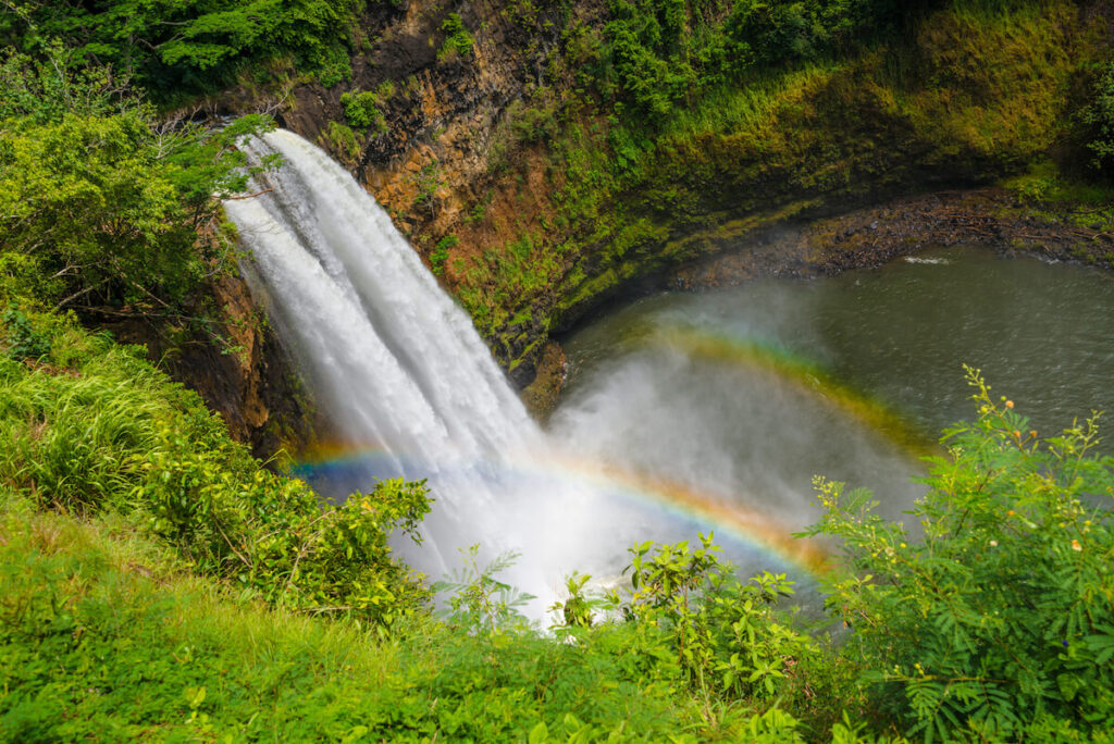 Image of a Kauai waterfall with a double rainbow at the pool