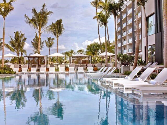 The Andaz Maui is one of the best Maui luxury hotels. Image of a pool surrounded by pool chairs and palm trees