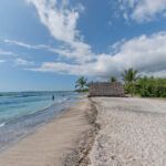 Find out the best Big Island beaches recommended by top Hawaii blog Hawaii Travel Spot! Image of a wide sandy beach with a Hawaiian hut at Kaloko-Honokokau National Historic Park