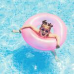 Find out the best Maui resorts for families recommended by top Hawaii blog Hawaii Travel Spot! Image of a girl in a pink inflatable ring in a swimming pool