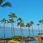 Find out the best Maui luxury hotels and resorts recommended by top Hawaii blog Hawaii Travel Spot! Image of a hotel pool and beach with palm trees