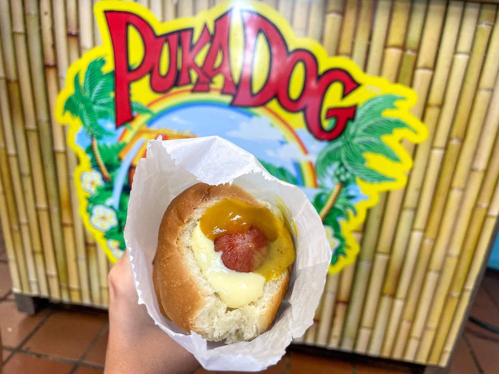 Best Kauai Cheap Eats: Image of a hot dog in front of the Puka Dog sign