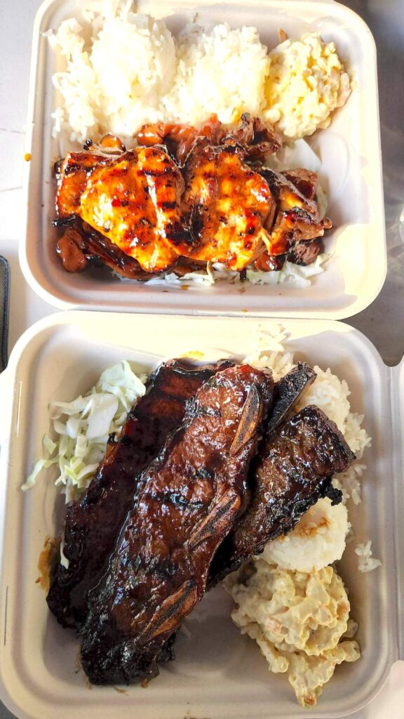 Plate lunches at Ted's Bakery in North Shore Oahu. Image of takeout boxes with kalbi, chicken, macaroni salad, and rice