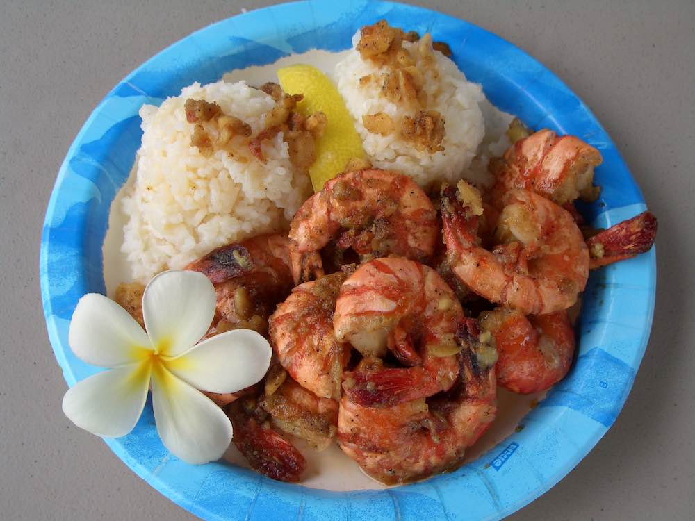 Giovanni's Shrimp. Image of a plate of Hawaiian style shrimp, rice, and lemon wedge.
