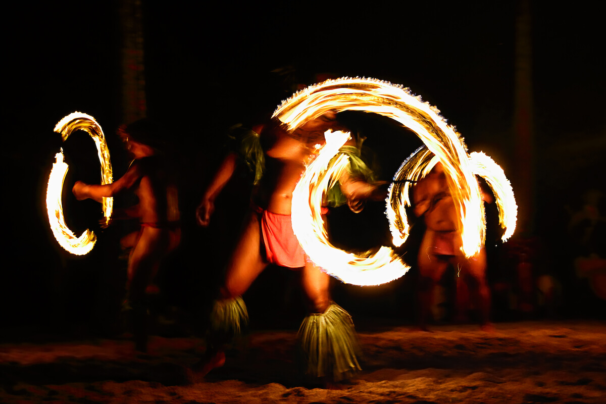 Find out the best luau in Kona recommended by top Hawaii blog Hawaii Travel Spot! Image of three Hawaiian fire knife dancers