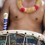 Find out how to choose the best luau on Oahu by top Hawaii blog Hawaii Travel Spot! Image of a Polynesian man playing a drum at the Polynesian Cultural Center on Oahu