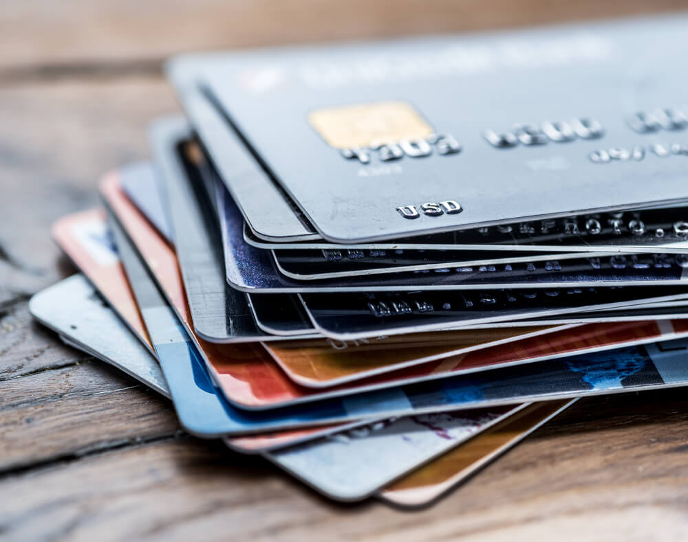 Credit card hacking can save you money on an affordable Hawaii honeymoon. Image of a stack of credit cards