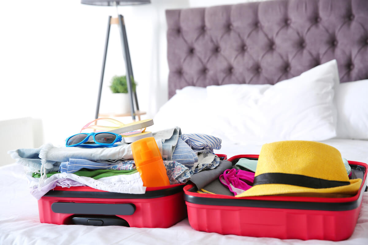Check out this Hawaii packing list for the airplane recommended by top Hawaii blog Hawaii Travel Spot! Image of an open suitcase with vacation clothing inside
