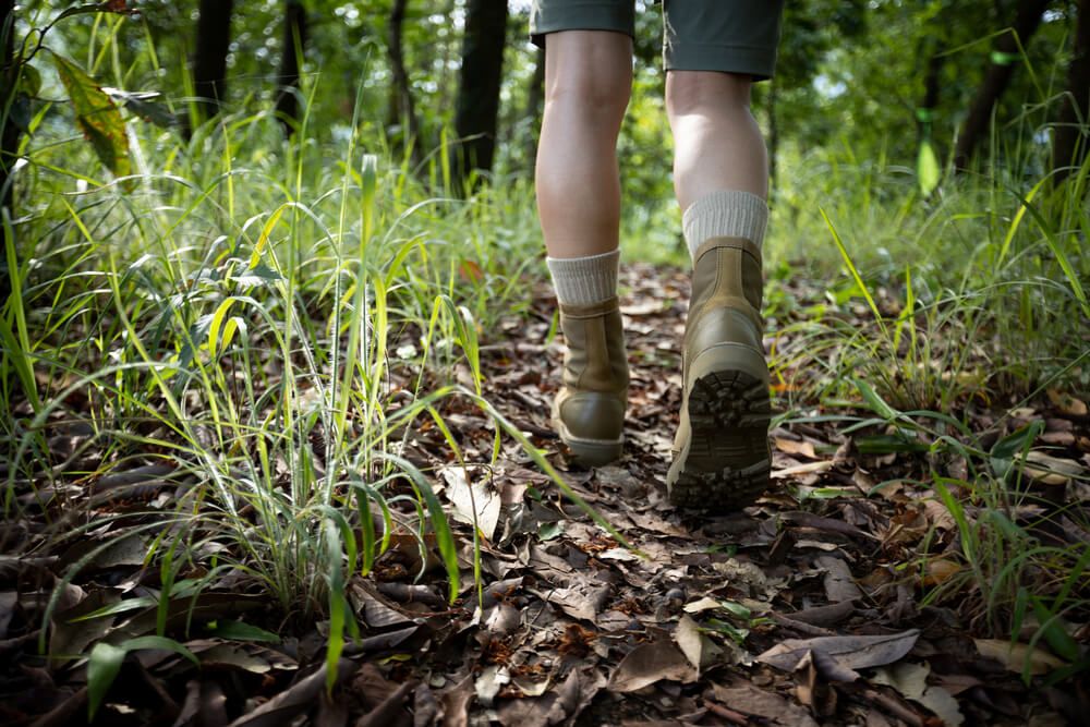 Hawaii hiking essentials: Image of someone wearing hiking boots on a trail