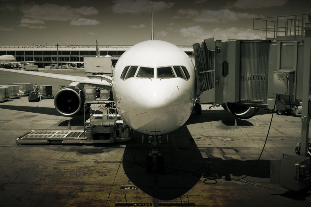 The Honolulu Airport is one of the spookiest haunted places in Hawaii. Black and white image of an airplane