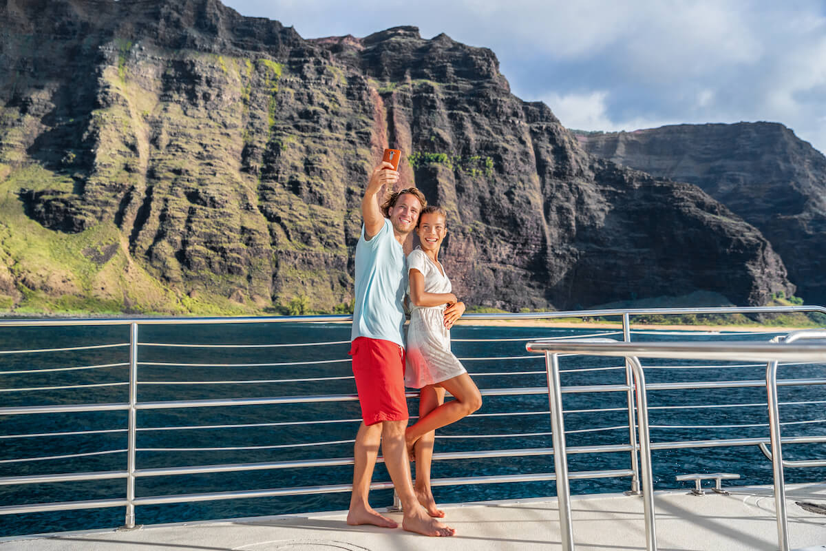 How many days on Kauai do you need? Find out what top Hawaii blog Hawaii Travel Spot says! Image of a couple on a Na Pali Coast cruise