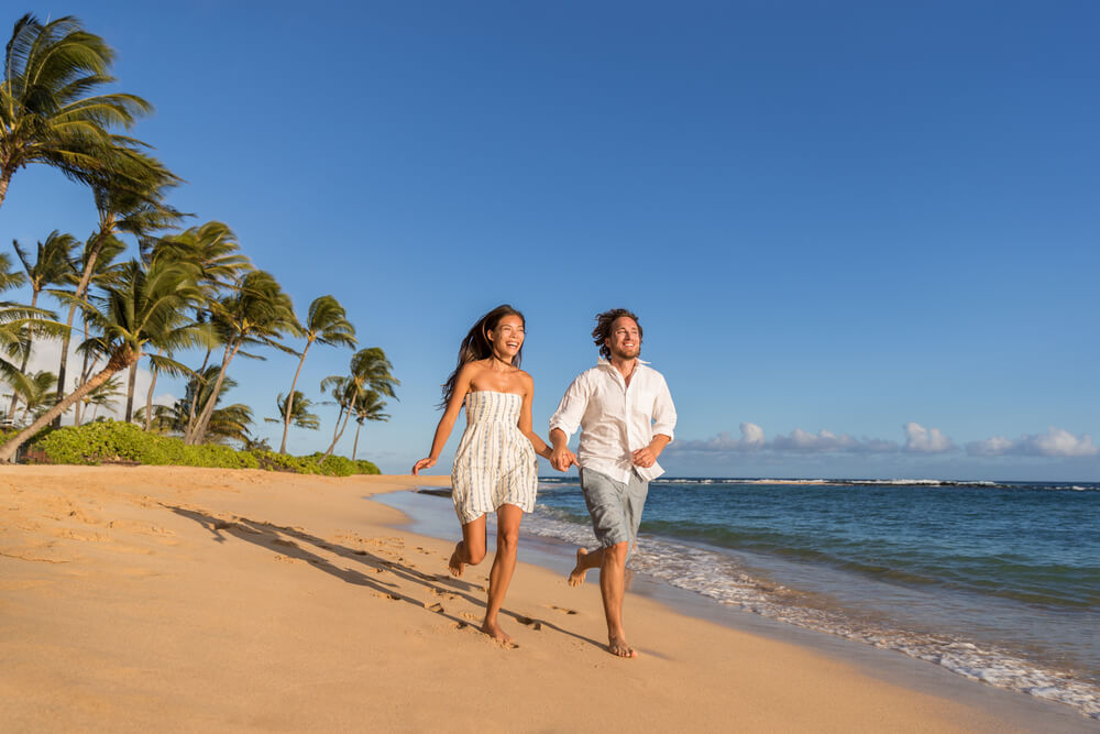 Poipu Kauai: Image of a couple running on a beach