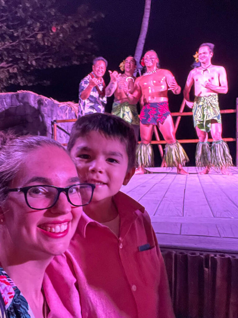 Image of a mom and boy with luau performers behind them