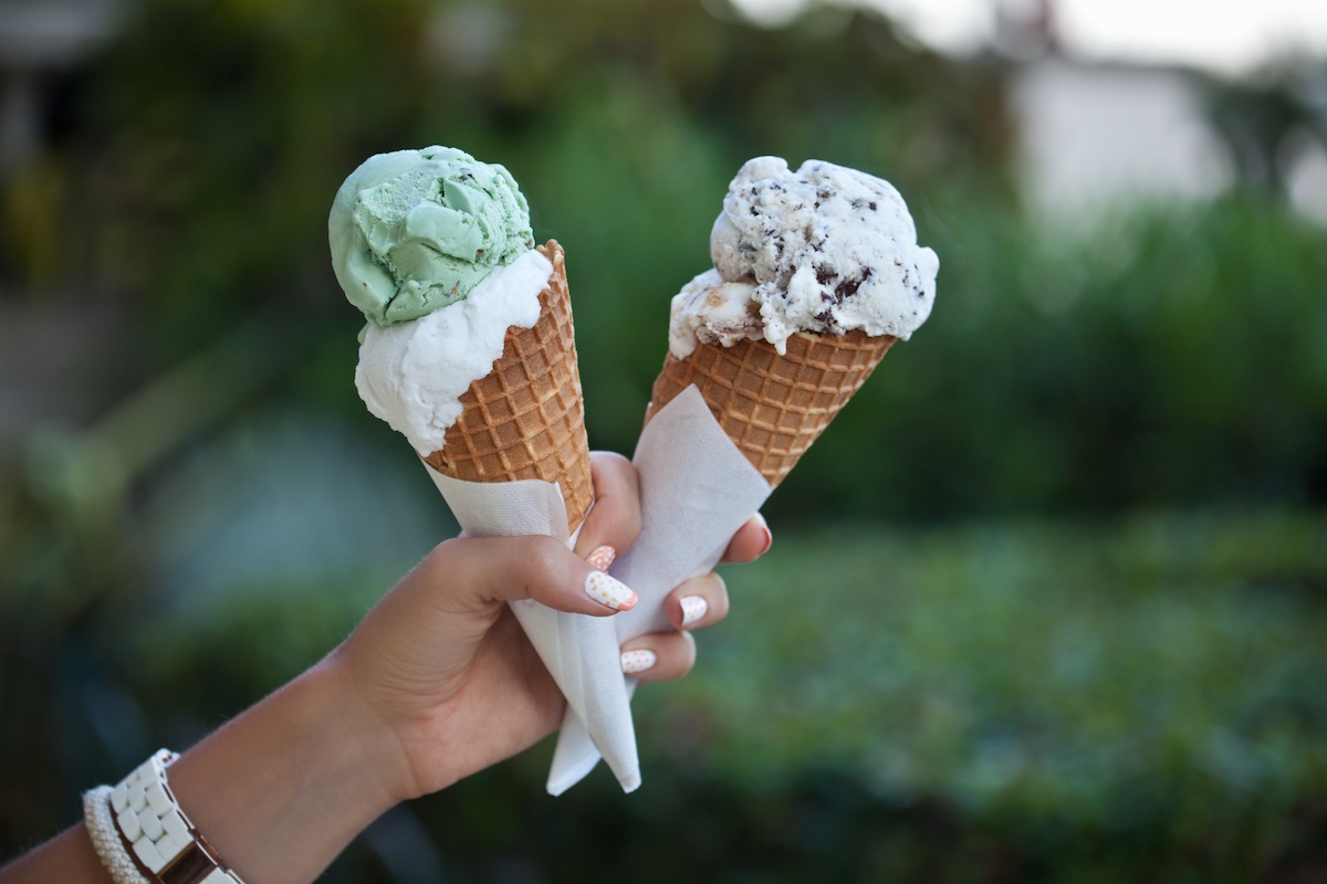 Find out the best Maui ice cream shops recommended by top Hawaii blog Hawaii Travel Spot. Image of Ice cream in waffle cones with two scoops in woman hand