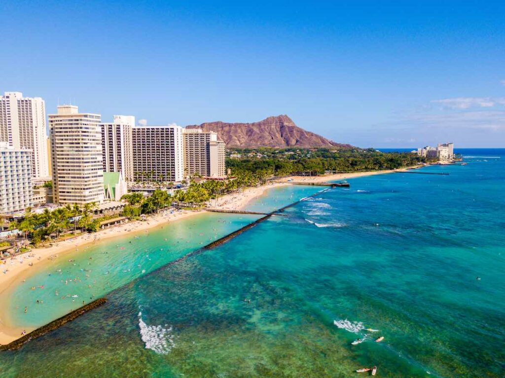 Heading to Oahu on a budget? Check out these cheap places to stay on Oahu recommended by top Hawaii blog Hawaii Travel Spot! Image of Waikiki Beach hotels and Diamon Head
