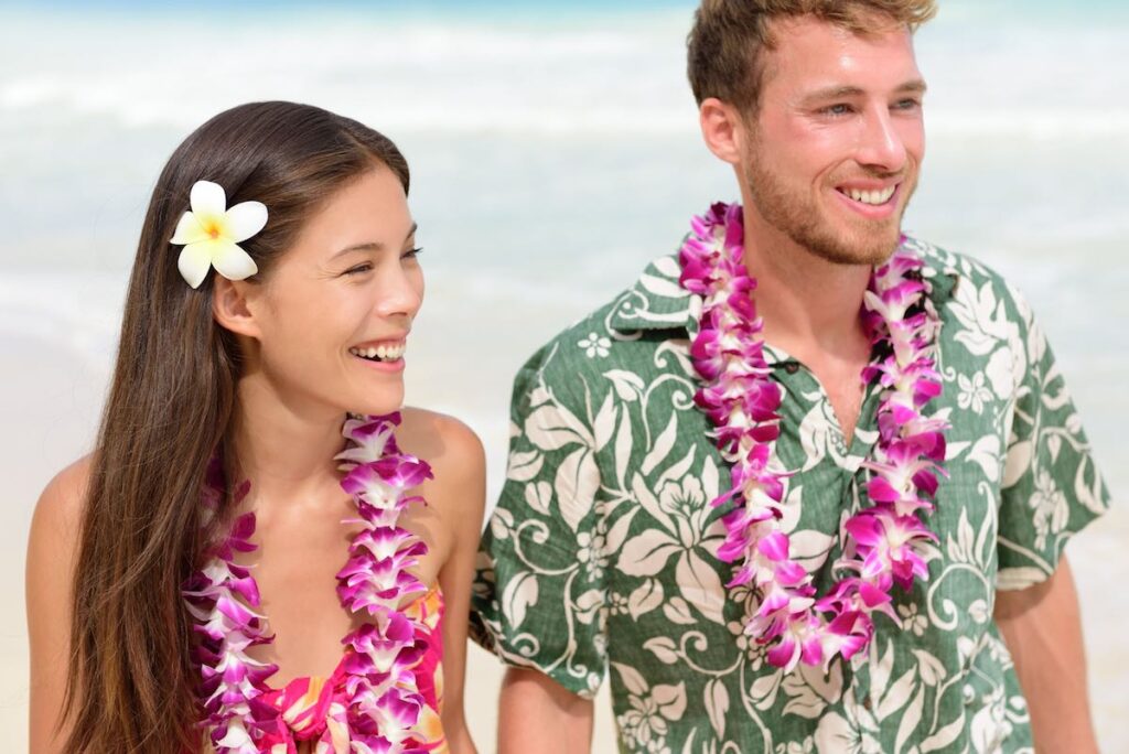 Image of a man and woman wearing purple orchid leis