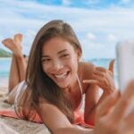 Check out this mega list of Hawaii captions for Instagram by top Hawaii blog Hawaii Travel Spot! Image of a woman taking a selfie at Waikiki Beach