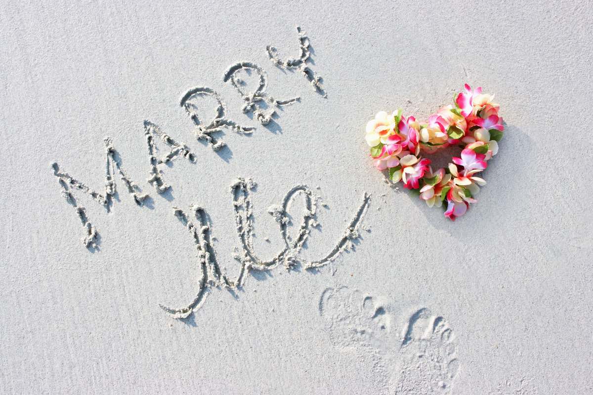 Check out this list of ideas for propsing on the beach in Hawaii by top Hawaii blog Hawaii Travel Spot. Image of the words Marry Me written in sand with a lei in the shape of a heart