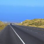 Check out the best Kona to Hilo drive options recommended by top Hawaii blog Hawaii Travel Spot! Image of a road in Kona Hawaii with the ocean in the background
