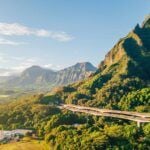 Check out the best things to do in Kaneohe Oahu recommended by top Hawaii blog Hawaii Travel Spot! Image of a highway going around tropical mountains as seen from Hoomaluhia Botanical Garden.